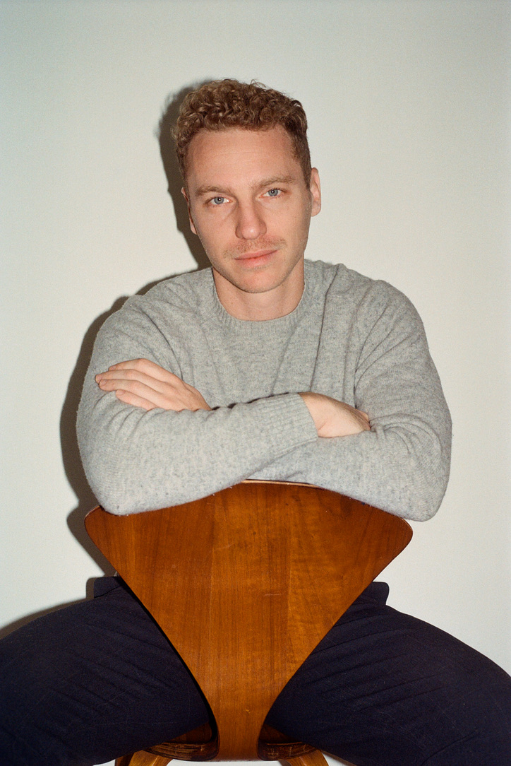 Rob Berry seated with a wooden chair